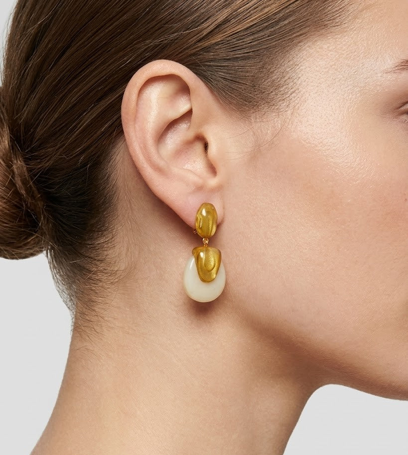 Perfil de modelo luciendo los pendientes Calista Ivory, mostrando su tamaño y cómo aportan luz al rostro.