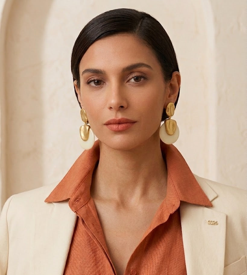 Perfil de modelo luciendo los pendientes Calista Ivory, mostrando su tamaño y cómo aportan luz al rostro.