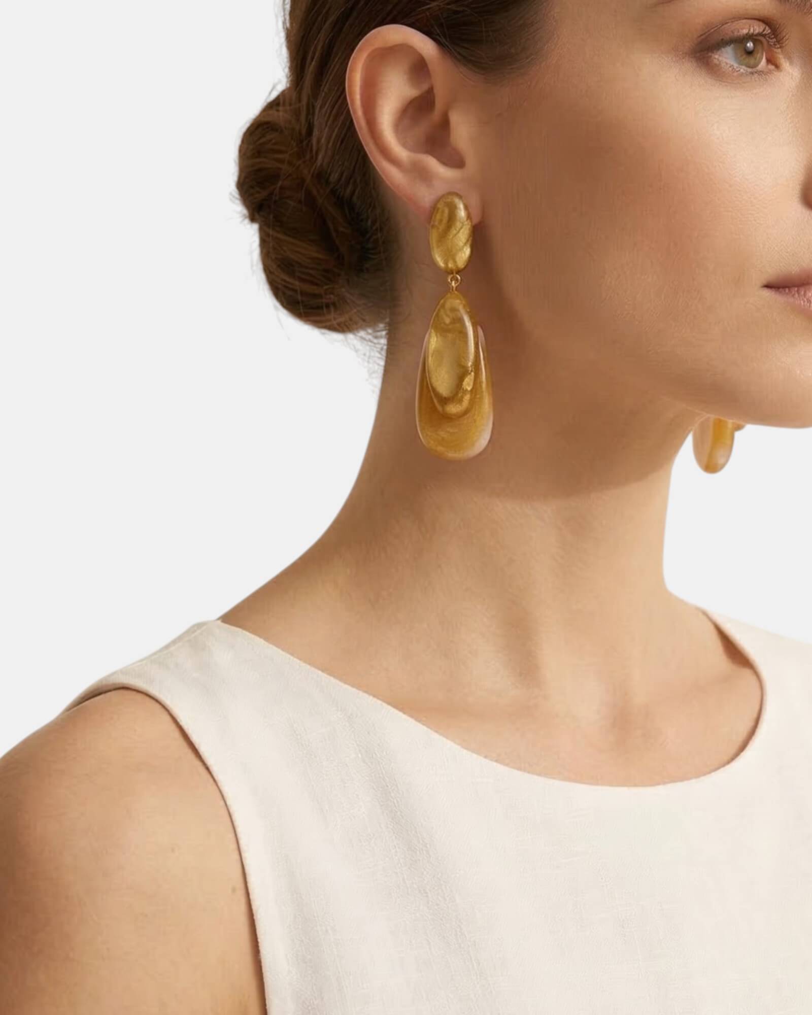 Mujer luciendo los pendientes Leda Rosewood con un recogido bajo, mostrando su tamaño statement y elegancia parisina.