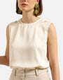 Mujer luciendo los pendientes Althea Verde de Dominique Denaive sobre un look en tonos crema, destacando su volumen y elegancia.