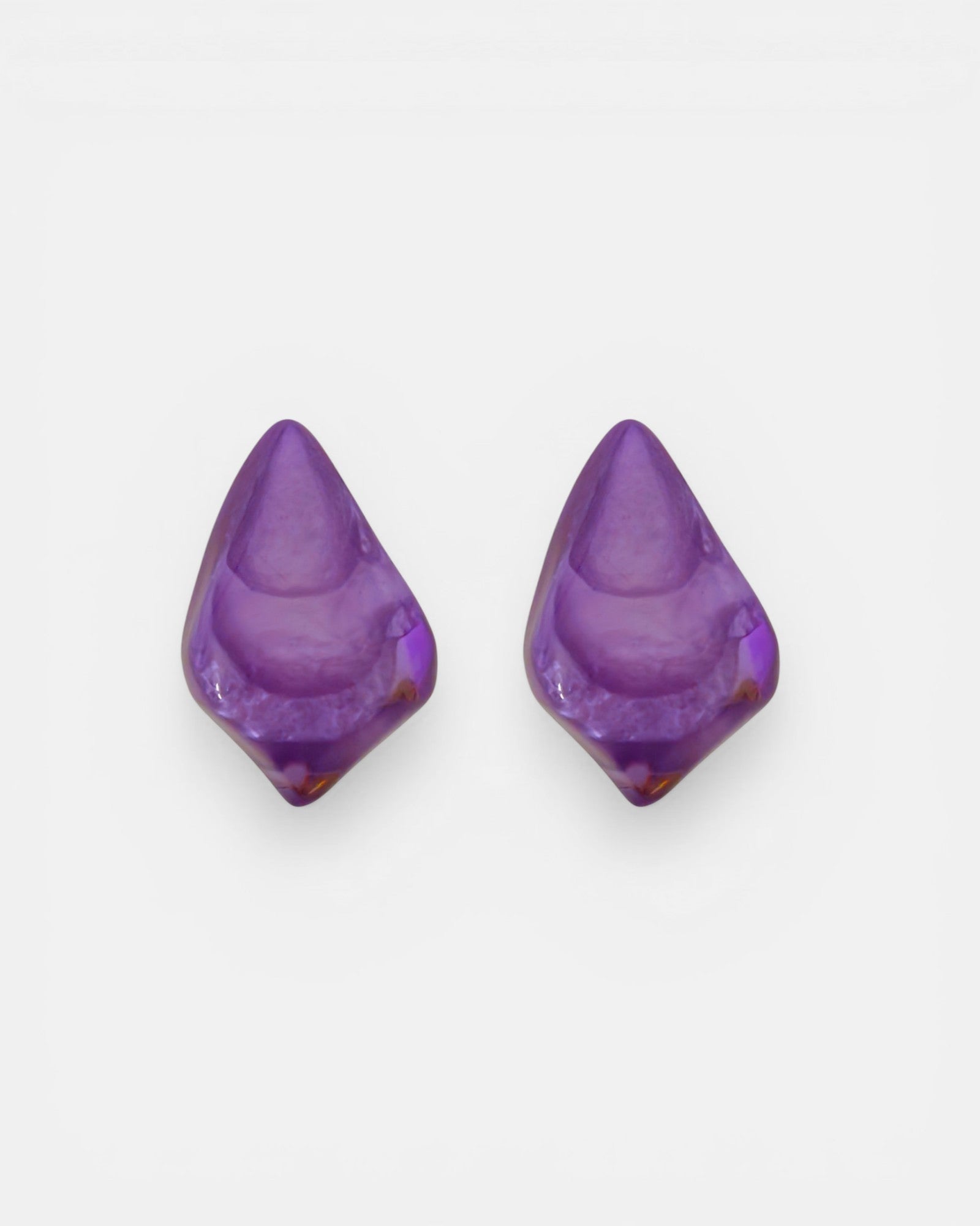 Pareja de pendientes orgánicos Violet de Dominique Denaive en resina violeta brillante sobre fondo blanco.