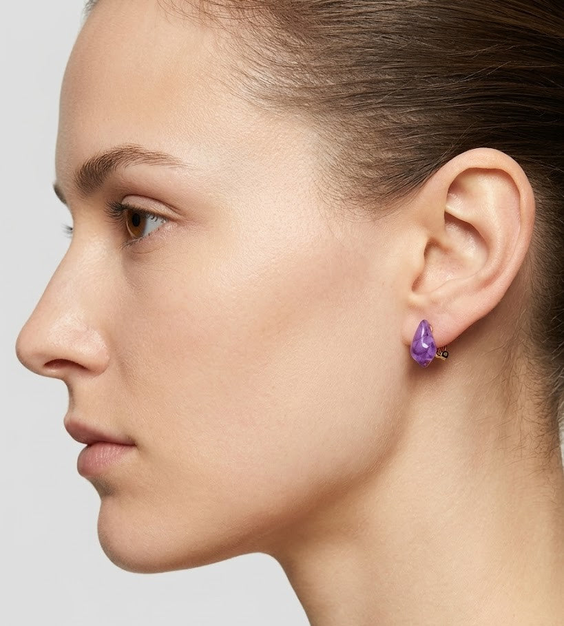 Perfil de modelo luciendo los pendientes Violet, mostrando su tamaño discreto y cómo aportan luz al rostro.