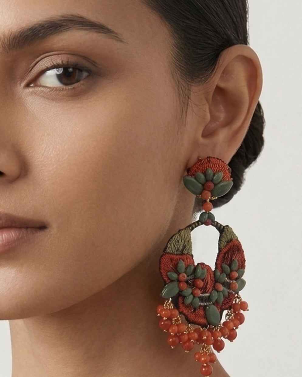 Mujer luciendo los pendientes maxi Dublos de bordado, destacando su tamaño statement y su colorido orgánico de fiesta.