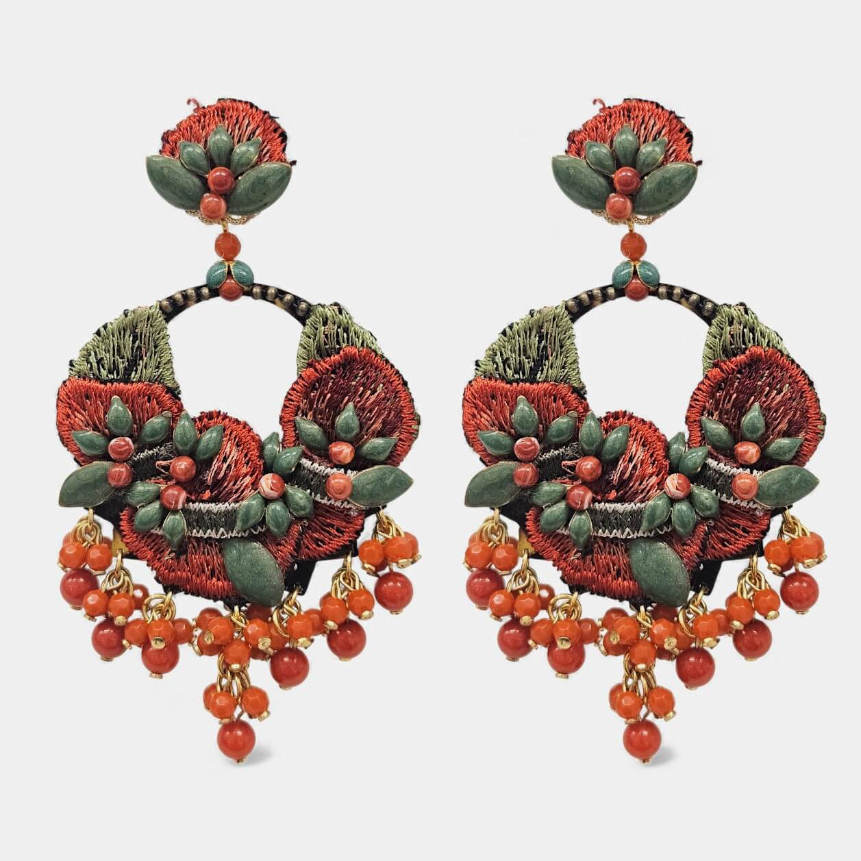 Pareja de pendientes Dublos con bordado floral artesanal en rojo coral y verde, con caída de bolas de piedra naturales sobre fondo blanco.