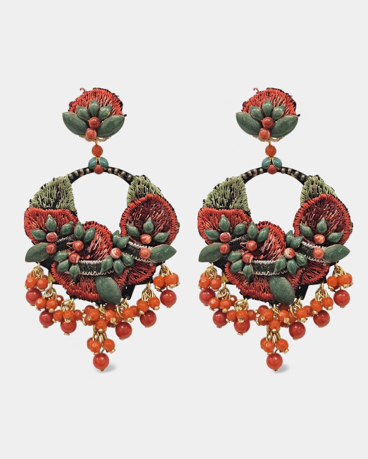 Pareja de pendientes Dublos con bordado floral artesanal en rojo coral y verde, con caída de bolas de piedra naturales sobre fondo blanco.