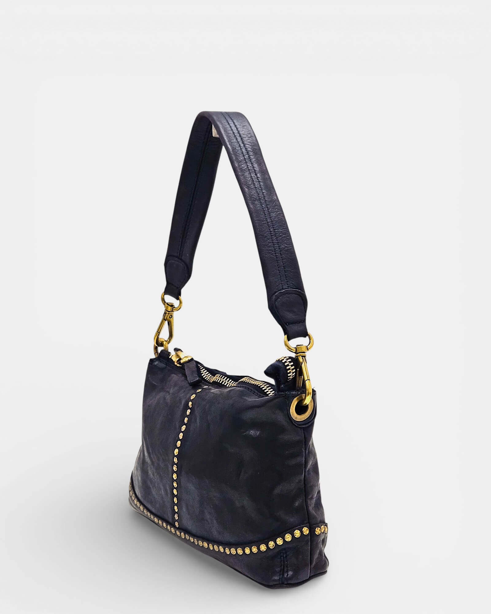 Vista lateral de pochette Campomaggi azul de piel con correa de hombro y tachuelas.