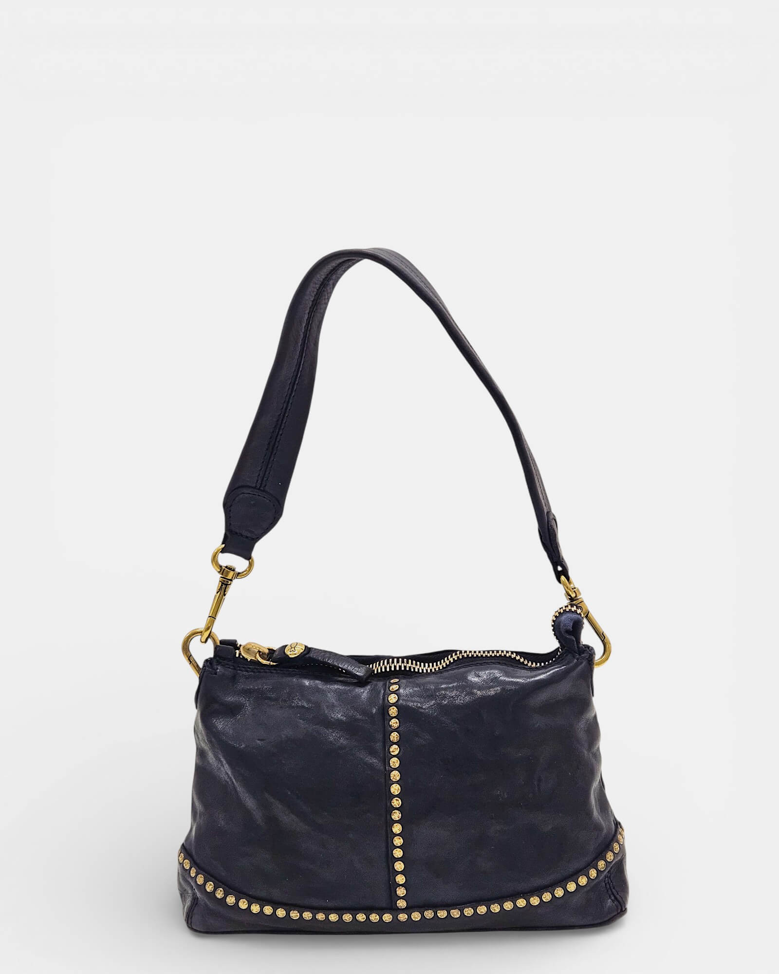 Vista frontal de bolso azul Campomaggi con línea vertical de tachuelas doradas.