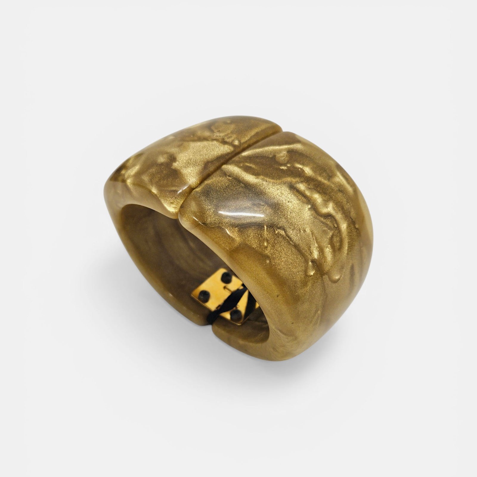 Brazalete rígido Coline de Dominique Denaive en resina ámbar y oro con diseño curvo sobre fondo blanco.