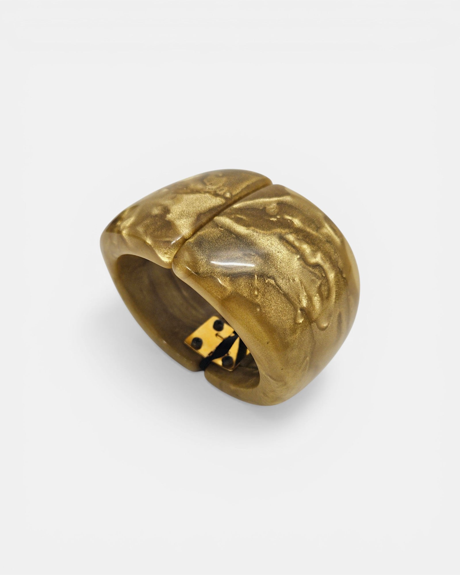 Brazalete rígido Coline de Dominique Denaive en resina ámbar y oro con diseño curvo sobre fondo blanco.