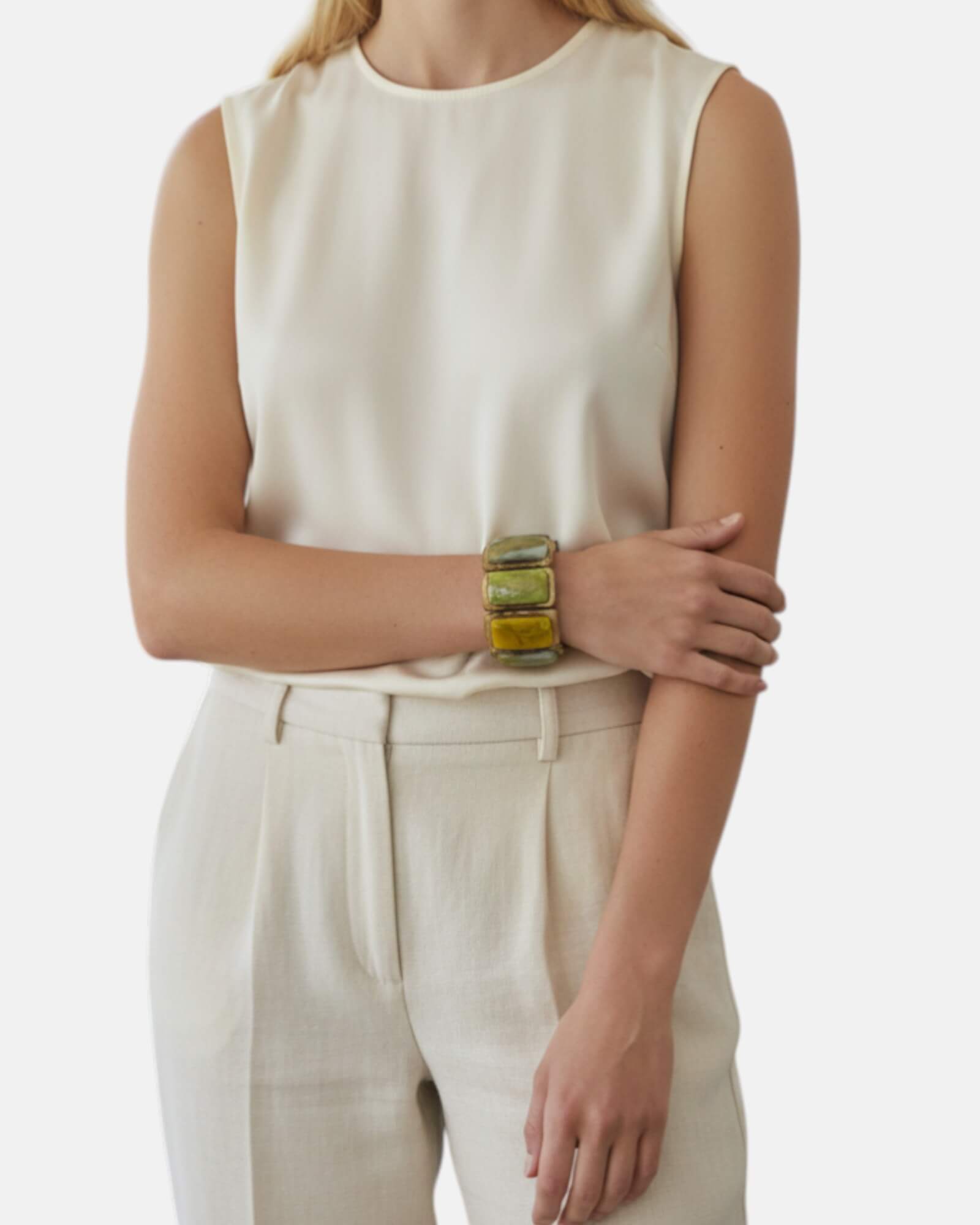 Mujer luciendo el brazalete Laika de Dominique Denaive sobre un look en tonos crema, destacando su volumen y elegancia.